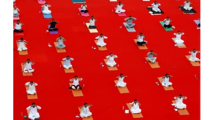 Los participantes realizan yoga durante el Día Mundial de Yoga en Ahmedabad, India