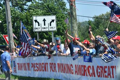 Los partidarios aplauden cuando el presidente Donald Trump se detiene para saludarlos después de abandonar el Trump National Golf Club en Bedminster, Nueva Jersey, el 26 de julio de 2020