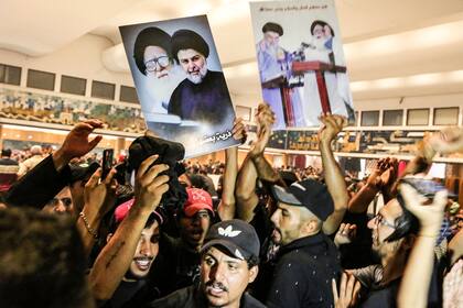 Los partidarios del clérigo iraquí Moqtada al-Sadr, que protestan contra la candidatura de un bloque rival a primer ministro, corean consignas en el interior del parlamento iraquí en la Zona Verde de alta seguridad de la capital, Bagdad, el 31 de julio de 2022, un día después de irrumpir en él