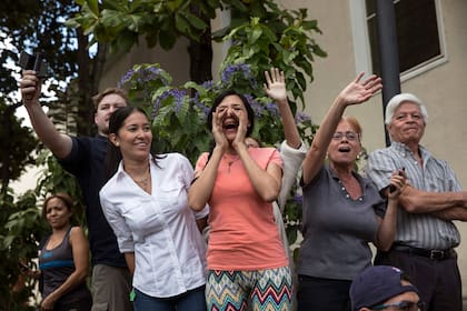 Los partidarios del líder de la Asamblea Nacional, Juan Guaidó, quien se declaró a sí mismo presidente interino, lo alientan después de asistir a misa en una iglesias