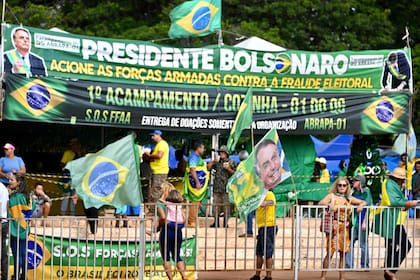 Los partidarios del presidente brasileño Jair Bolsonaro realizan una manifestación contra los resultados de las elecciones presidenciales que eligieron a Luiz Inacio Lula da Silva como nuevo presidente en un campamento improvisado frente al cuartel general del Ejército en Brasilia, el 29 de diciembre de 2022