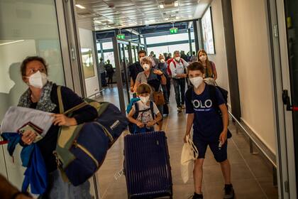 Los pasajeros con mascarilla de un vuelo desde Frankfurt llegan al aeropuerto de Corfú el 1 de julio de 2020