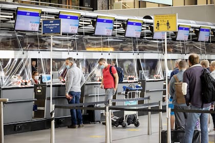 Pasajeros hacen cola en el mostrador de facturación del aeropuerto de Schiphol en Ámsterdam; Holanda tomó restricciones por la aparición de la nueva variante