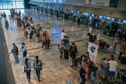 Los pasajeros se registran en el mostrador de Lufthansa en el aeropuerto OR Tambo de Johannesburgo, el lunes 29 de noviembre de 2021. La Organización Mundial de la Salud instó a los países de todo el mundo a no imponer prohibiciones de vuelo a las naciones del sur de África debido a la preocupación por la nueva variante omicron. 