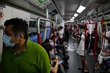 Los pasajeros usan mascarillas mientras viajan en el metro en Hong Kong el 29 de julio de 2020, después de que entraron en vigencia nuevas medidas de distanciamiento social