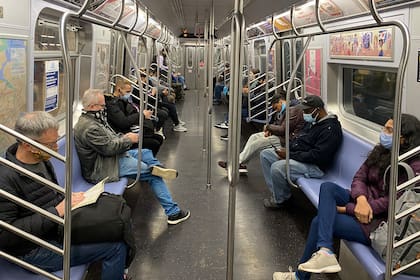 Los pasajeros viajan en el metro de la ciudad de Nueva York manteniendo la distancia social el 5 de noviembre de 2020, mientras la pandemia de coronavirus continúa en todo el mundo