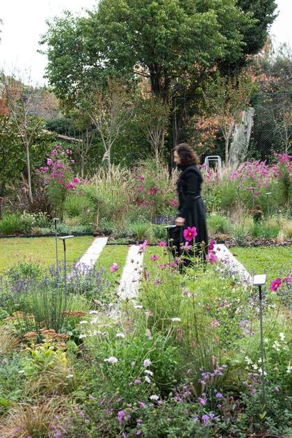 Los pasos de hormigón que se insertan en los canteros ofician de portal entre los dos grandes espacios.