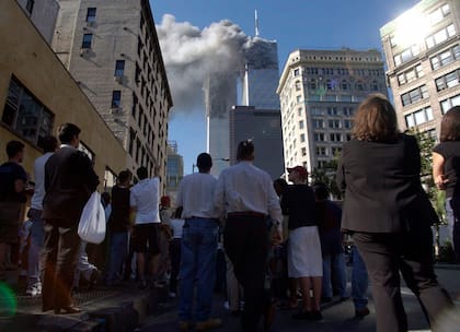 Los peatones en el bajo Manhattan ven salir el humo del World Trade Center de Nueva York el martes 11 de septiembre de 2001