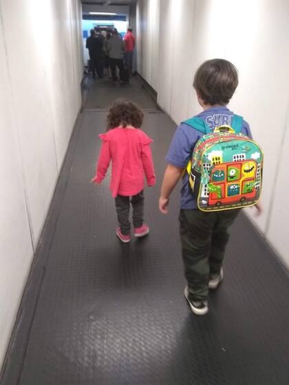 Los pequeños Nina (4) y Benicio (7), y los únicos dos niños del pueblo, cuando subían al avión en Ezeiza, sin imaginar el futuro