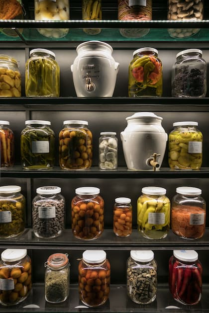 Los pickles en conserva, prolijamente dispuestos sobre los estantes, se usan en los platos para aportar la cuota de acidez.