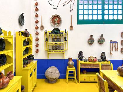 Los pisos de cemento alisado se cubrieron de amarillo intenso, y las aberturas llevan un verde esmeralda con marco color terracotta. Una paleta singular y apasionada, como todo en el universo de Frida.