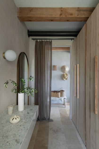 Los pisos de travertino combinan piezas de 40 y 60 cm de ancho. Al ser de partidas distintas, el dibujo quedó levemente rayado y, aunque inesperado, el efecto terminó encantando al Estudio.