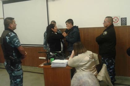 Los policías observan con atención el inusual gesto de la mujer con el victimario de su hijo