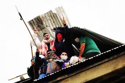 Los presos se asoman a través del techo destruido del penal de Devoto