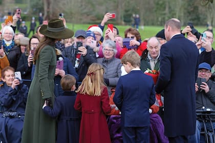 Los príncipes de Gales y sus hijos saludan a la gente.
