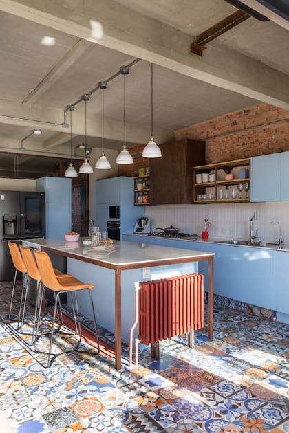 Los radiadores antiguos están elevados y pintados de rojo para acentuar su presencia. El piso es el mismo modelo 'Volta' (San Lorenzo Design) visto en el toilette