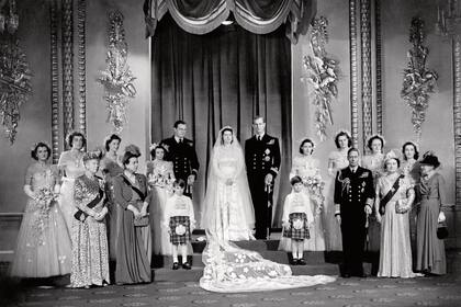 Los recién casados en una fotografía oficial con sus familias en el Palacio de Buckingham. En la parte de atrás, la segunda desde la izquierda, está la gran amiga de la Reina, Lady Pamela Mountbatten, ahora Hicks. Frente a ella está la reina María y a su lado, la madre de Felipe, la princesa Alicia. A la izquierda de la novia está el padrino David Mountbatten, el tercer marqués de Milford Haven. La princesa Margarita, al lado del novio, fue dama de honor.