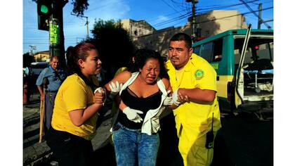Los rescatistas María Martínez y Renato Landaverde ayudan a una mujer que fue atropellada por un autobús en San Salvador,
