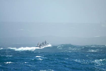 Los rescatistas navegan en un bote dentro del área de operaciones de rescate