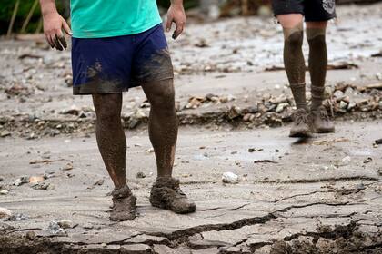 Los residentes de California con lodo hasta las rodillas, tras el paso de la tormenta tropical Hilary. (AP Foto/Marcio José Sánchez)