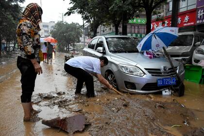 Los residentes limpian las secuelas de la inundación en la ciudad de Gongyi, en la provincia de Henan, en el centro de China