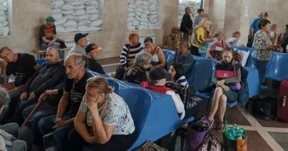 Los residentes locales esperan un tren de evacuación en una estación de Jersón