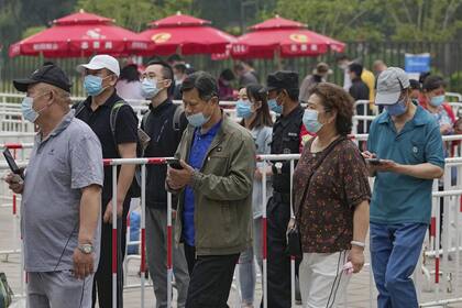 Los residentes que usan máscaras faciales para ayudar a frenar la propagación del coronavirus se alinean para recibir la vacuna Sinopharm Covid-19 en el Distrito Central de Negocios de Beijing, el miércoles 2 de junio de 2021 (AP Photo / Andy Wong)