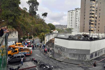 Los residentes se reúnen afuera de la subestación eléctrica dañada de la compañía de electricidad estatal Corpoelec en Caracas, donde se produjeron explosiones a principios del 11 de marzo, mientras continúa un apagón masivo que afecta a algunas zonas del país.