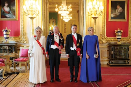 Los reyes Camilla y Carlos III y Emmanuel y Brigitte Macron posan para la foto oficial. La Reina eligió un traje de Fiona Claire, mientras que la primera dama francesa optó por un vestido de cuello cerrado en crêpe de lana de su íntimo amigo, Nicolas Ghesquière, director creativo de
Louis Vuitton. Le sumó una capa decorada con piedras preciosas.