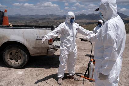 Los sepultureros se preparan para dos entierros en el Cementerio Municipal número 13 en Tijuana, Estado de Baja California, México, el 12 de mayo de 2020, durante la pandemia de coronavirus