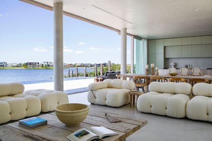 Los sillones ‘Camaleonda’ (un modelo clásico de Mario Bellini para B&B Italia) son los grandes protagonistas del living. Para potenciar la ausencia de límites, instalaron ventanales con DVH y perfiles de PVC símil madera que abren casi todo el ancho del ambiente.