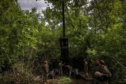 Los soldados ucranianos colocan un obús M777 en un grupo de árboles para camuflarse en la región de Donetsk, Ucrania, el domingo 22 de mayo de 2022. (Ivor Prickett/The New York Times)