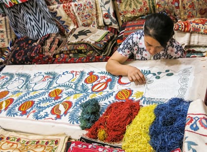 Los suzanis son tapices bordados a mano. Originalmente, las muchachas ya en la adolescencia comenzaban a diseñar y bordar su suzani, que luego será parte de su dote. Los diseños son muy alegóricos, por ejemplo, mostrando árboles y ramas que simbolizan la familia que esperan formar.