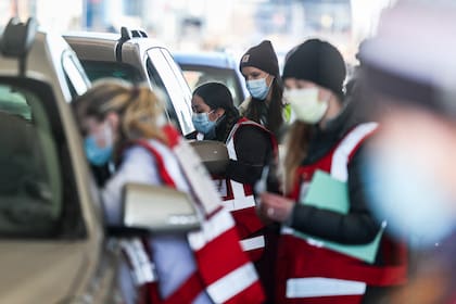 Los trabajadores de la salud de UCHealth reciben pacientes para su segunda dosis de una vacuna Covid-19 durante un evento de vacunación masiva en el estacionamiento de Coors Field el 20 de febrero de 2021 en Denver, Colorado
