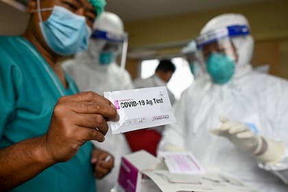 Los trabajadores de la salud muestran los kits de prueba de hisopado del nuevo coronavirus en la autopista Yangon-Mandalay, en Myanmar, el 13 de octubre de 2020
