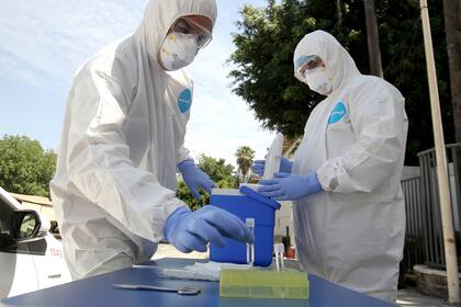 Los trabajadores de la salud se preparan para realizar una prueba de RCP en conductores que muestran síntomas sospechosos de Covid-19, en Guadalajara, México, el 14 de abril de 2020