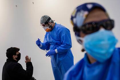 Los trabajadores de salud del Servicio de Emergencias de Madrid (SUMMA) realizan pruebas rápidas de antígenos para Covid-19 en el barrio sureño de Vallecas en Madrid