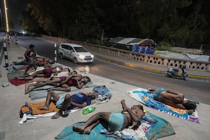 Los trabajadores duermen al lado de una carretera en una noche caliente en Lucknow, India, viernes, 14 de junio de 2024. En los últimos tres meses y medio, la ola de calor que azota desde hace un mes amplias zonas de la India ha causado la muerte de más de 100 personas y ha provocado más de 40.000 casos sospechosos de insolación, según informó el jueves un funcionario del Ministerio de Sanidad.