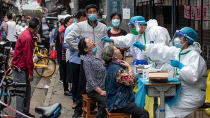 Los trabajadores médicos toman muestras de hisopos de los residentes para realizarles la prueba del coronavirus COVID-19 en una calle de Wuhan en la provincia central de Hubei en China el 15 de mayo de 2020 (STR / AFP / AFP a través de Getty Images / CNN).