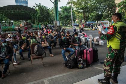 Los trabajadores migrantes que regresaron de Malasia y Singapur esperan la detección de Covid-19 en Surabaya el 28 de abril de 2021 antes de ser puestos en cuarentena
