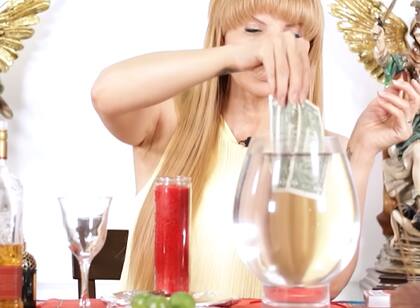 Los tres billetes de US$1 se colocan dentro de la copa de cristal con agua (YouTube/Mhoni Vidente)