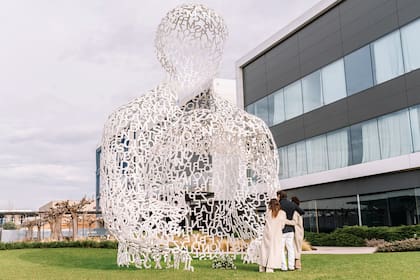 Los
tres hijos del fundador de Mango abrazados
en señal de unidad fraternal frente a la
escultura del artista Jaume Plensa titulada
House of Knowledge