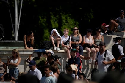 Los turistas esperan bajo el sol abrasador para ver la ceremonia del Cambio de Guardia afuera del Palacio de Buckingham, durante un clima cálido en Londres