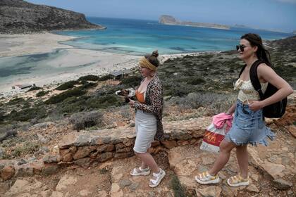 Los turistas rusos llevan sus comidas mientras caminan hacia la playa de Balos y su laguna en la parte noreste de la isla de Creta