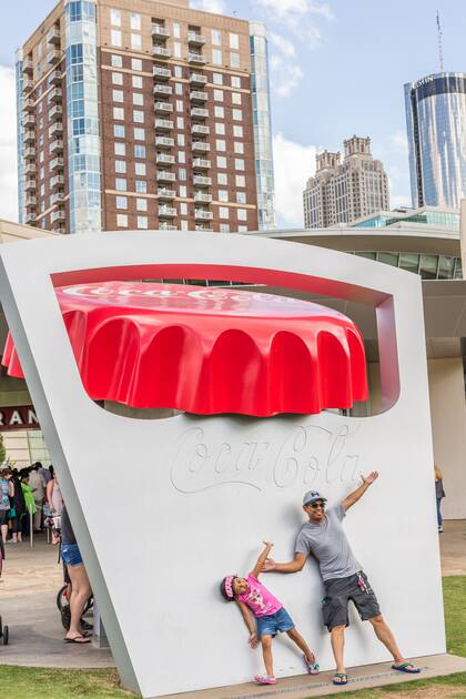Los turistas se sacan fotos en la entrada del Mundo de Coca-Cola.