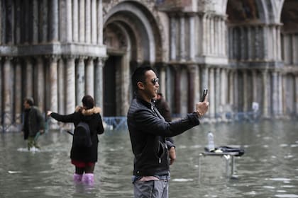 Los turistas toman fotos en una inundada