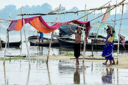 Los vendedores trasladan sus refugios improvisados ​​de las orillas del río Ganges a medida que aumenta el nivel del agua