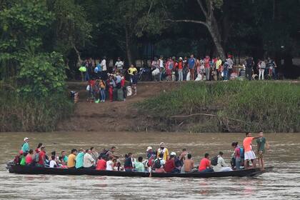 Los venezolanos cruzan el río Arauca, la frontera natural entre Venezuela y Colombia, para viajar a Arauquita, Colombia, el viernes 26 de marzo de 2021. Los venezolanos buscan refugio en Colombia esta semana tras los enfrentamientos entre el ejército venezolano y un grupo armado colombiano. 