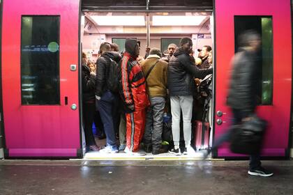 Los viajeros abordan un tren en la estación de Saint-Lazare en París, durante una huelga de los empleados de la compañía ferroviaria estatal SNCF por el plan del gobierno francés para revisar el sistema de jubilación del país