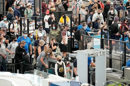 Los viajeros pasan por el punto de control de seguridad del norte en el Aeropuerto Internacional de Denver el viernes, Estados Unidos, 2 de julio de 2021 (David Zalubowski/AP)